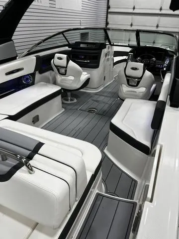 Slide: The Image of 2024 Chaparral 287 SSX boat interior with white seating and modern dashboard. - 15