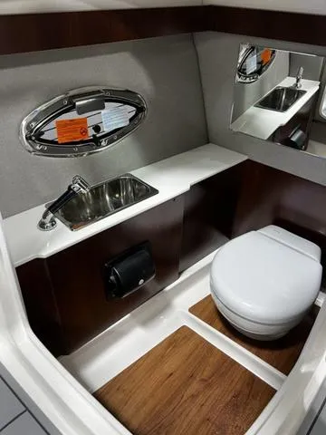 Slide: The Image of 2024 Chaparral 287 SSX boat bathroom with sink, toilet, and mirror. - 30