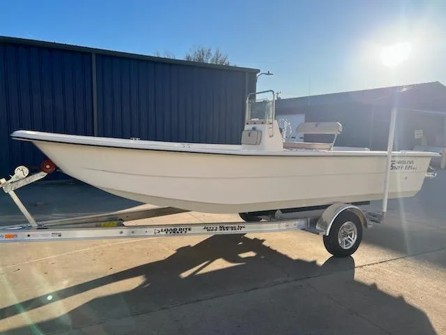 The Image of 2025 Carolina Skiff E21 DLX CC boat on trailer in sunlight. - 1
