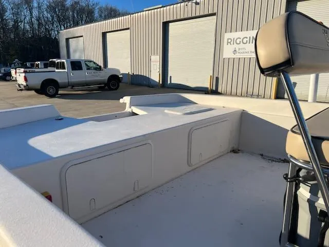 Slide: The Image of 2025 Carolina Skiff E21 DLX CC boat at a rigging facility with a truck nearby. - 4