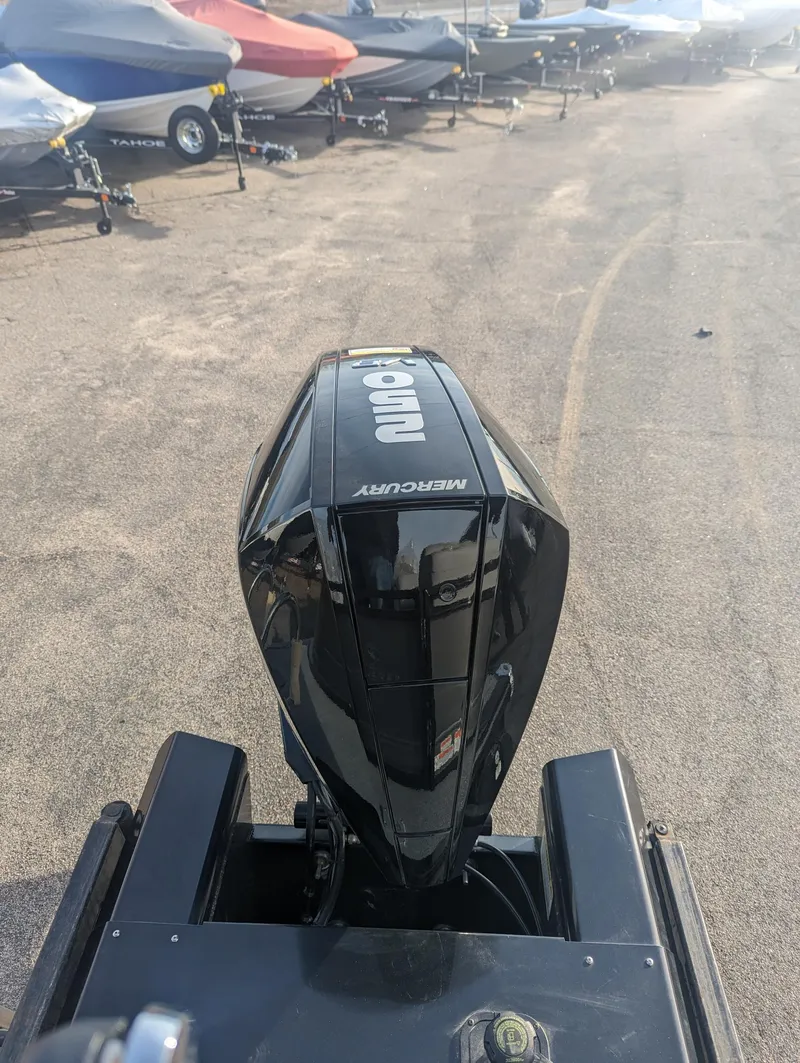 Slide: The Image of 2024 Regency 230 LE3 boat with Mercury outboard motor in a marina setting. - 6