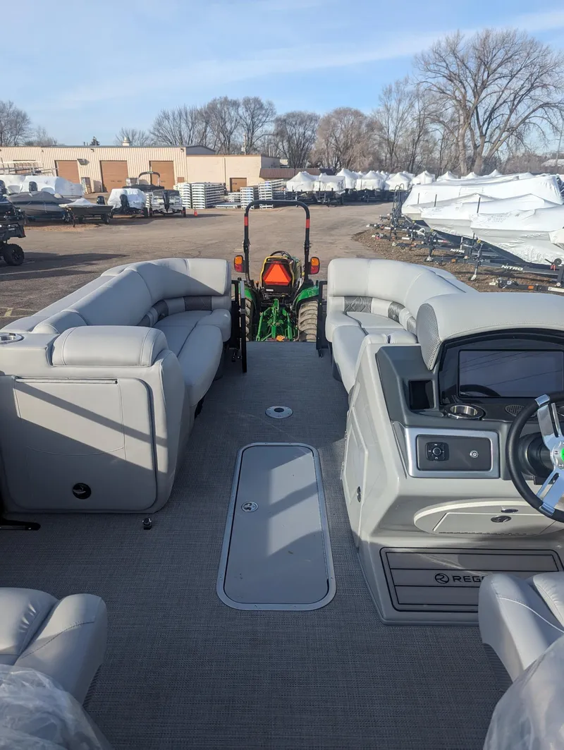 Slide: The Image of 2024 Regency 230 LE3 pontoon boat interior with plush seating and modern dashboard. - 7