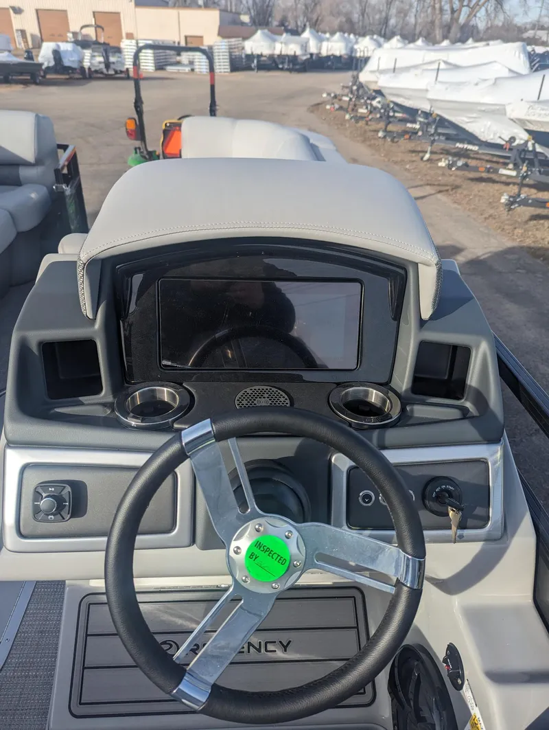 Slide: The Image of 2024 Regency 230 LE3 boat dashboard with steering wheel and control panel. - 8