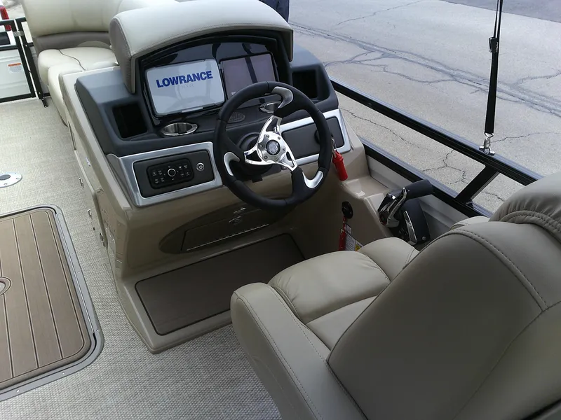 Slide: The Image of 2024 Regency 230 DL3 boat cockpit with steering wheel and Lowrance display. - 4