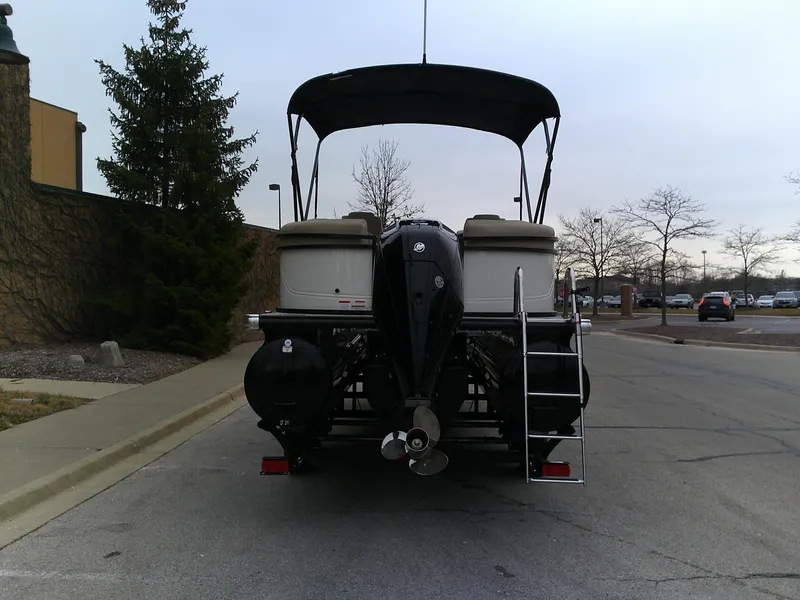 Slide: The Image of 2024 Regency 230 DL3 pontoon boat, rear view with outboard motor and ladder. - 7