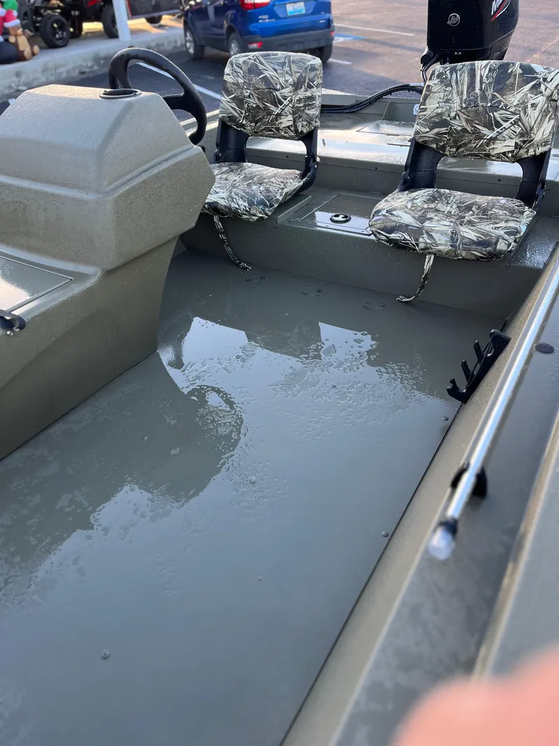 Slide: The Image of 2024 Tracker Grizzly 1754 SC boat interior with camo seats and steering console. - 2