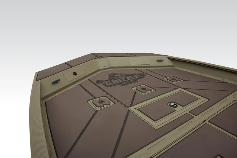 Slide: The Image of 2024 Tracker Grizzly 2072 CC boat deck with storage compartments and logo. - 29