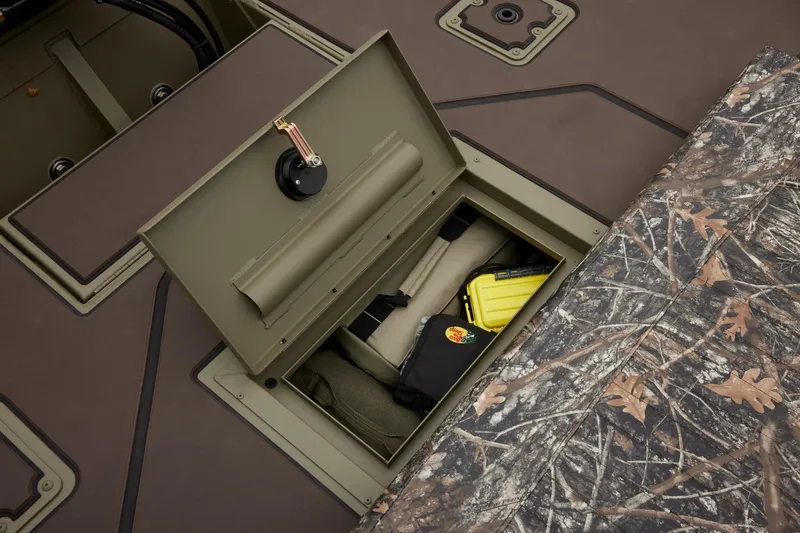 Slide: The Image of 2024 Tracker Grizzly 2072 CC storage compartment with camo design and gear inside. - 40