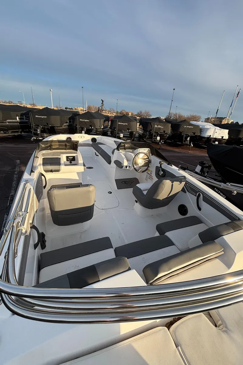 Slide: The Image of 2024 Tahoe T21 boat interior with seating and steering wheel, docked outdoors. - 11