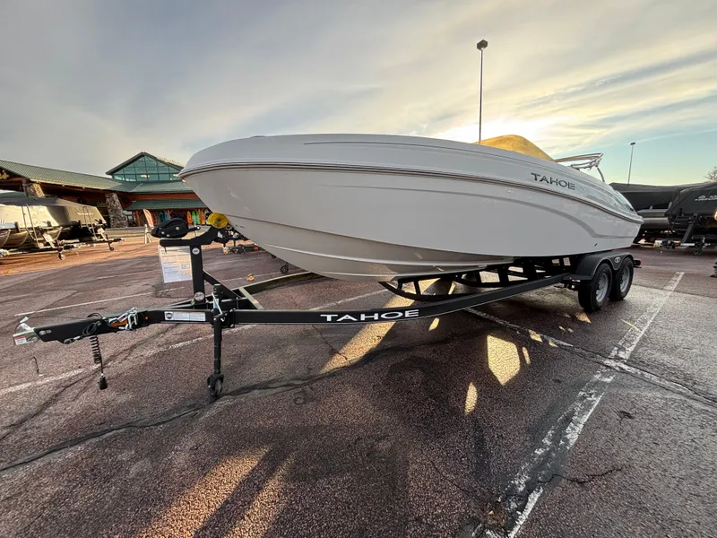 Slide: The Image of 2024 Tahoe T21 boat on trailer in parking lot at sunset. - 2