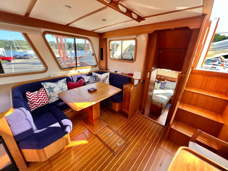Slide: The Image of Interior of 2001 Sabre Sabreline 47 yacht with wooden flooring and blue cushioned seating. - 14