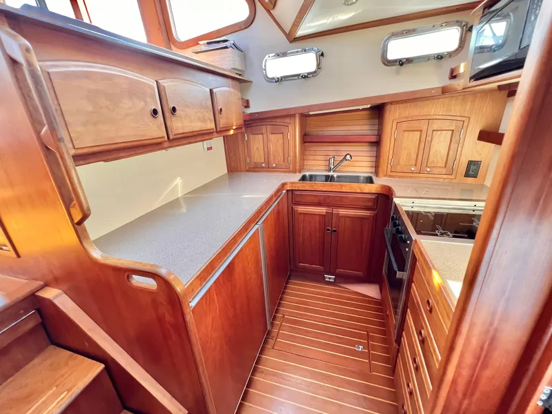 Slide: The Image of 2001 Sabre Sabreline 47 yacht kitchen with wooden cabinetry and modern appliances. - 17