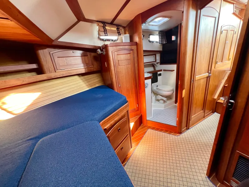 Slide: The Image of 2001 Sabre Sabreline 47 yacht interior with wooden cabinetry and blue cushioned seating. - 8
