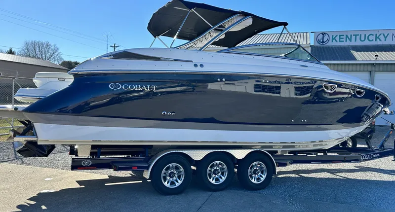 Slide: The Image of 2006 Cobalt 323 boat on a triple-axle trailer, parked outdoors. - 4