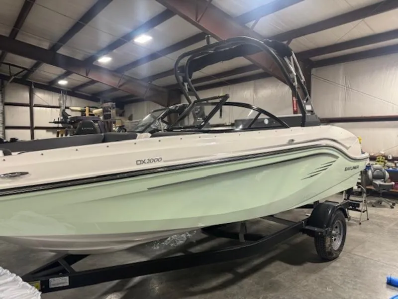 The Image of 2024 Bayliner DX2000 boat in a warehouse, side view. - 1