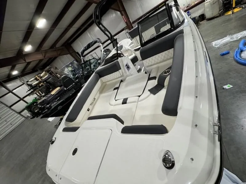Slide: The Image of 2024 Bayliner DX2000 boat interior in a warehouse, showcasing seating and storage. - 3