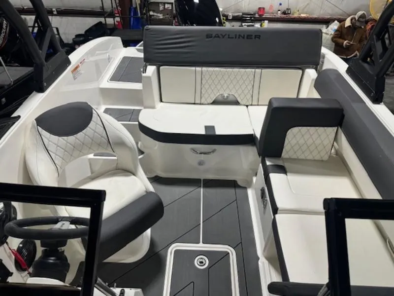 Slide: The Image of 2024 Bayliner DX2000 boat interior with white and gray seating and steering wheel. - 4