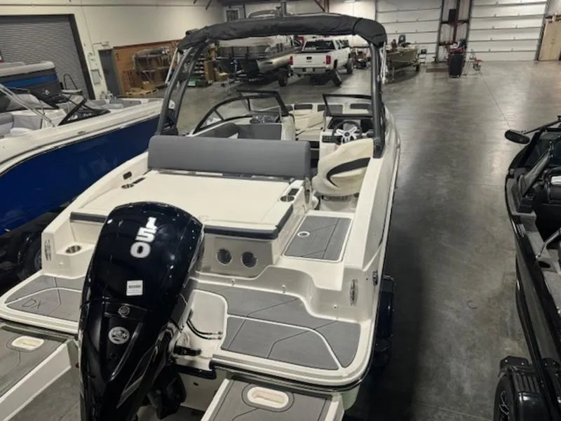 Slide: The Image of 2024 Bayliner DX2000 boat in a showroom, rear view with outboard motor. - 7