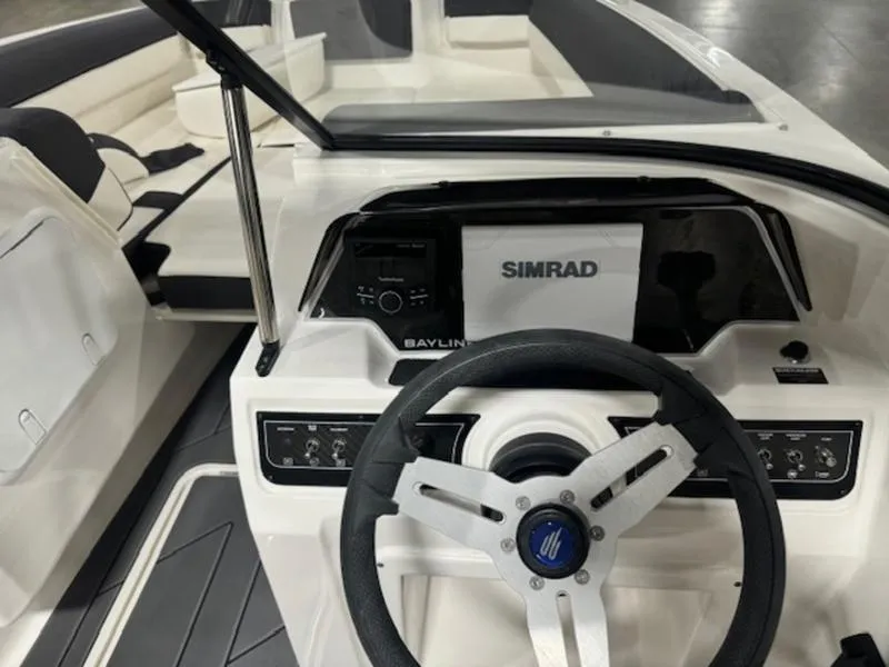 Slide: The Image of 2024 Bayliner DX2000 boat dashboard with Simrad navigation system and steering wheel. - 9
