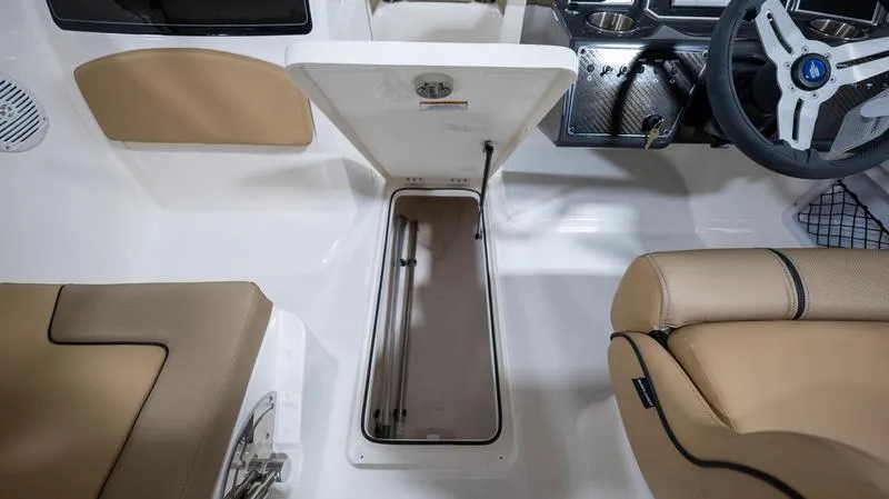 Slide: The Image of 2024 Bayliner VR5 Bowrider OB interior with open storage compartment and beige seating. - 14
