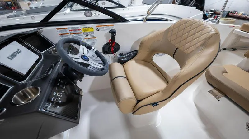 Slide: The Image of 2024 Bayliner VR5 Bowrider OB cockpit with beige seating and modern steering console. - 15