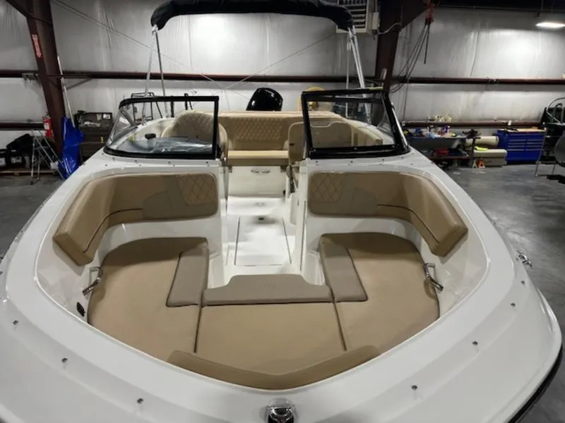 Slide: The Image of 2024 Bayliner VR5 Bowrider OB with spacious seating in a warehouse setting. - 2