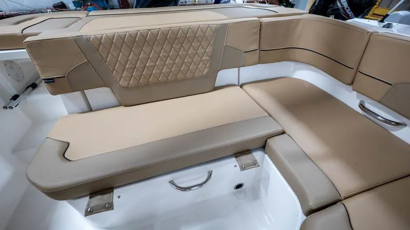 Slide: The Image of 2024 Bayliner VR5 Bowrider OB interior with tan cushioned seating and diamond-patterned backrest. - 24