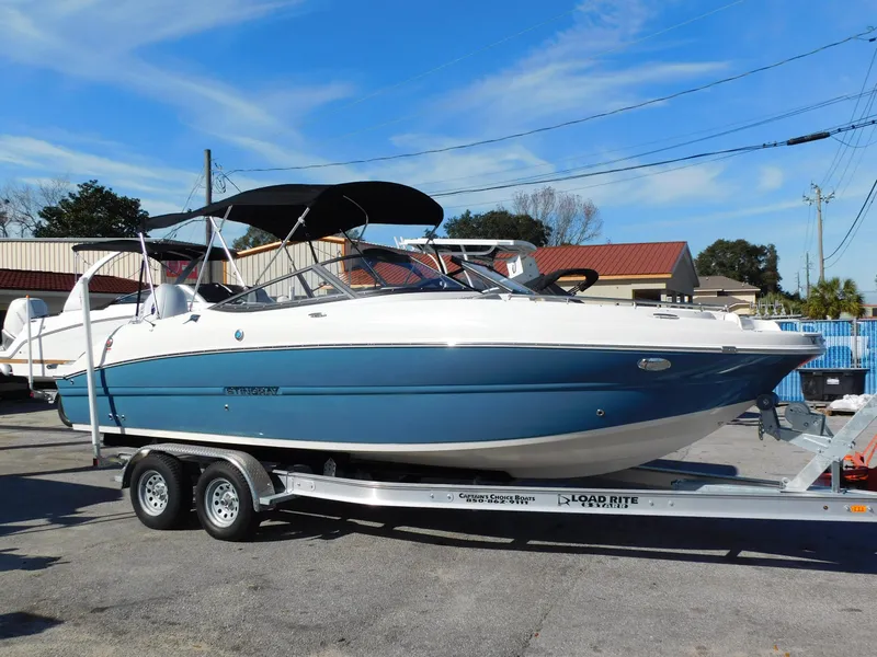 Slide: The Image of 2024 Stingray 231 DC boat on a trailer, blue and white exterior. - 1