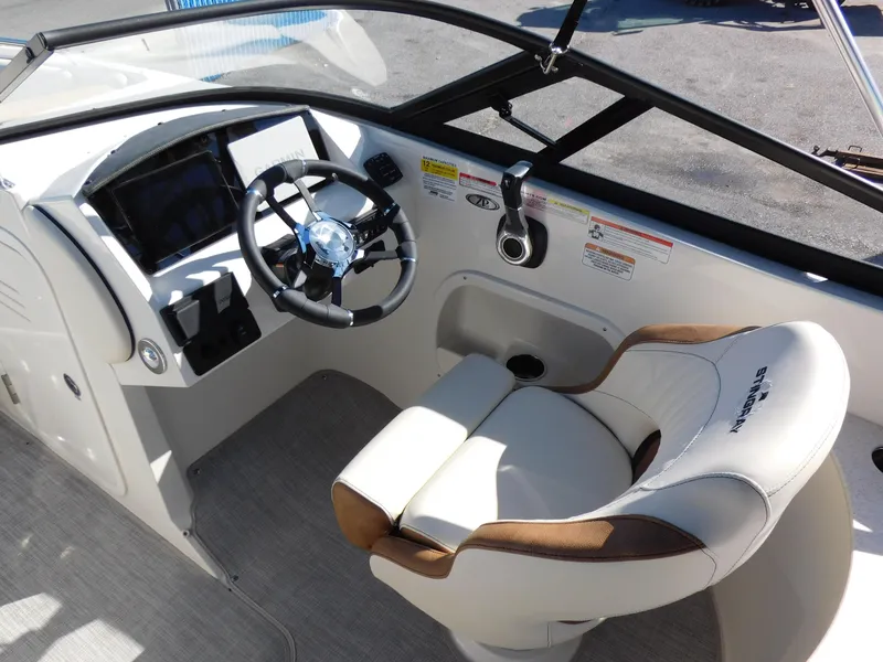 Slide: The Image of 2024 Stingray 231 DC boat cockpit with steering wheel and captain's chair. - 16