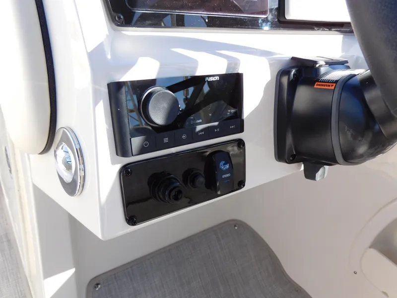 Slide: The Image of Close-up of the 2024 Stingray 231 DC boat's control panel and steering wheel. - 18