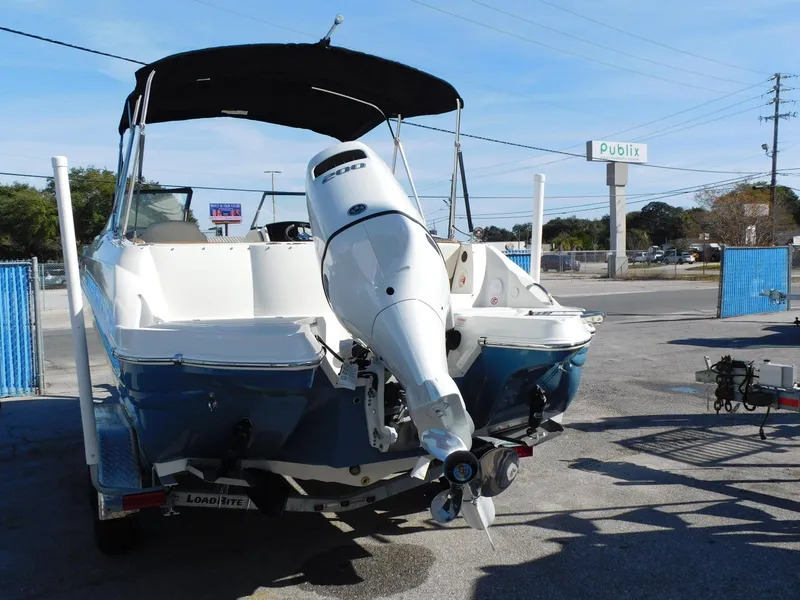 Slide: The Image of 2024 Stingray 231 DC boat with outboard motor in parking lot near Publix. - 2