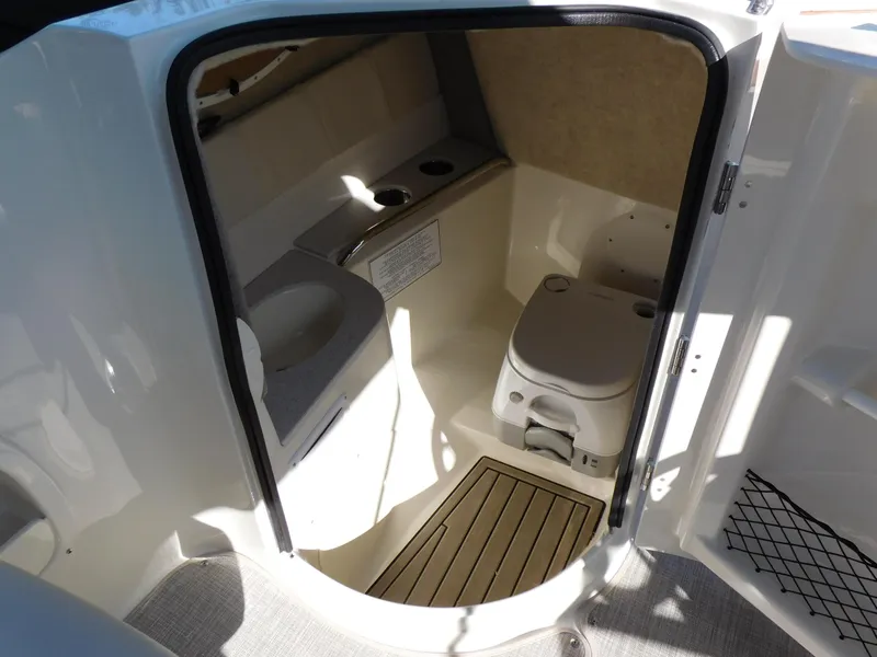 Slide: The Image of 2024 Stingray 231 DC boat interior bathroom with toilet and sink. - 24