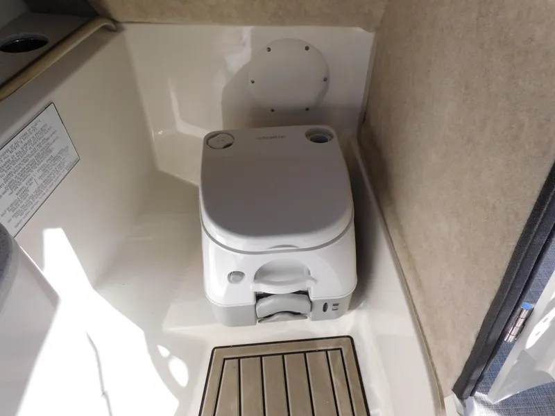 Slide: The Image of 2024 Stingray 231 DC boat interior with portable toilet. - 26