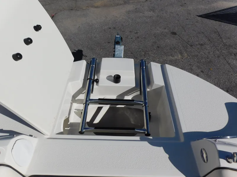 Slide: The Image of 2024 Stingray 231 DC boat with open storage compartment and ladder. - 31