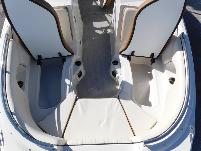 Slide: The Image of 2024 Stingray 231 DC boat interior with open storage compartments and seating. - 33