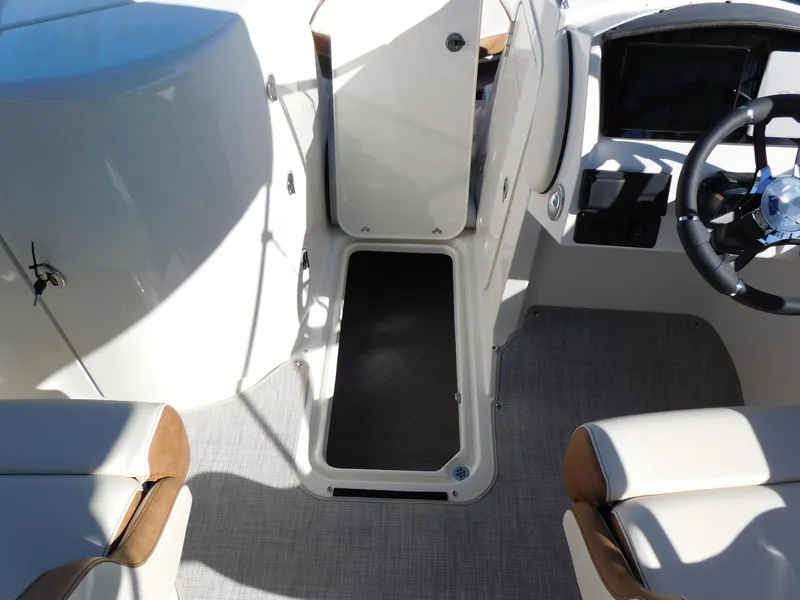 Slide: The Image of 2024 Stingray 231 DC boat interior with open storage compartment and steering wheel. - 36