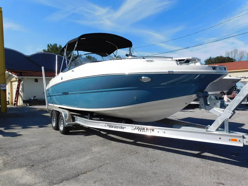 Slide: The Image of 2024 Stingray 231 DC boat on a Load Rite trailer, blue and white hull. - 4