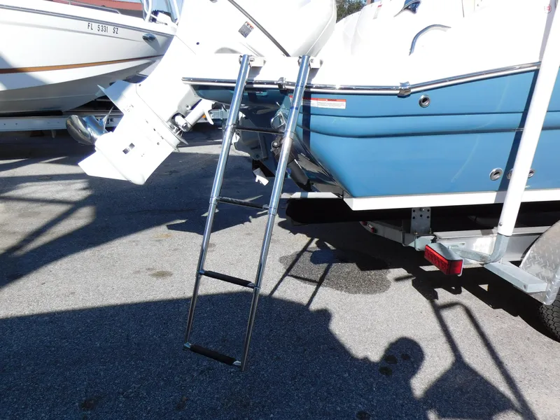 Slide: The Image of 2024 Stingray 231 DC boat with ladder and outboard motor. - 5