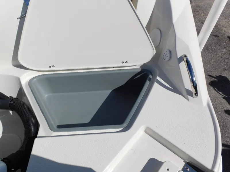 Slide: The Image of 2024 Stingray 231 DC boat storage compartment with open lid. - 6