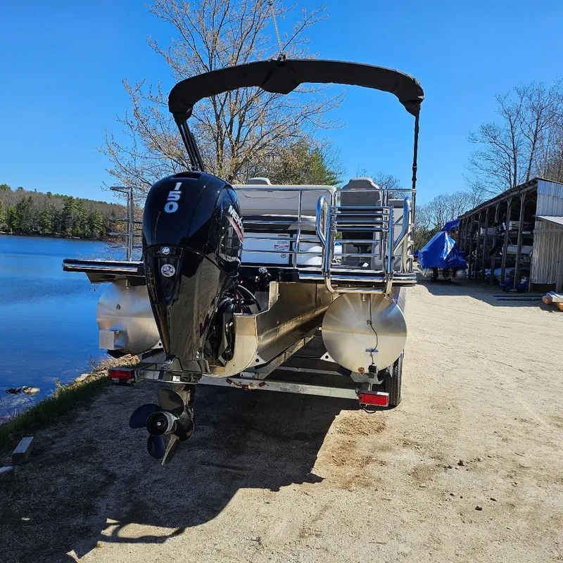 Slide: The Image of 2023 Starcraft SLS 5 Q DH pontoon boat with outboard motor by a lake. - 2