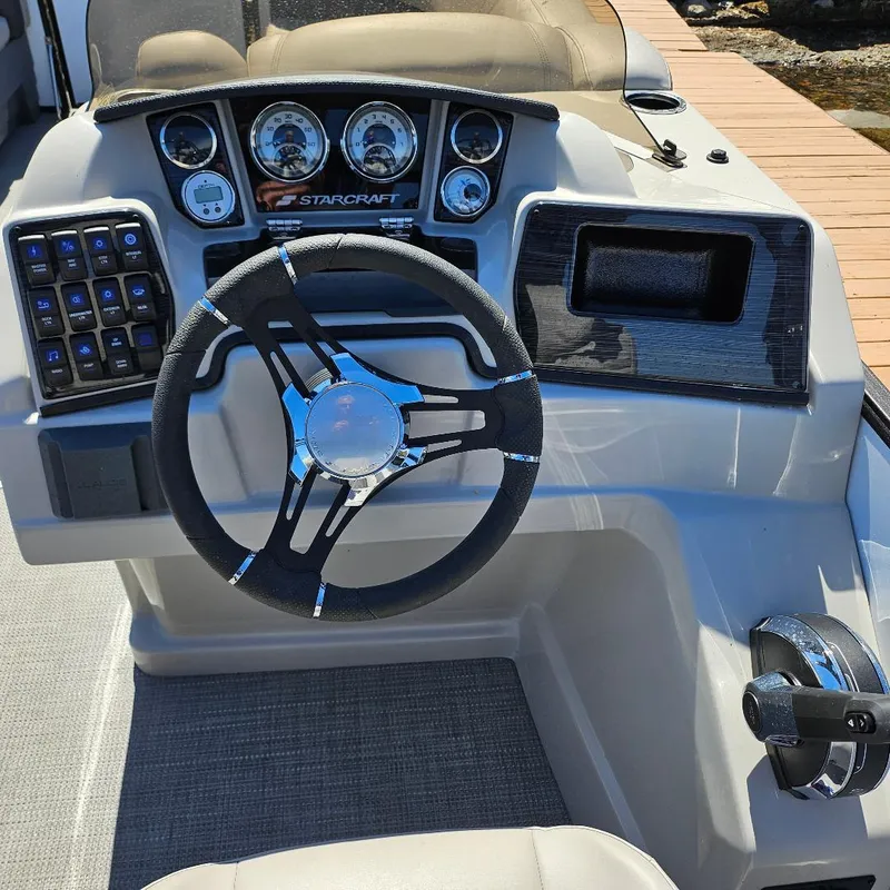 Slide: The Image of 2023 Starcraft SLS 5 Q DH boat dashboard with steering wheel and control panel. - 7