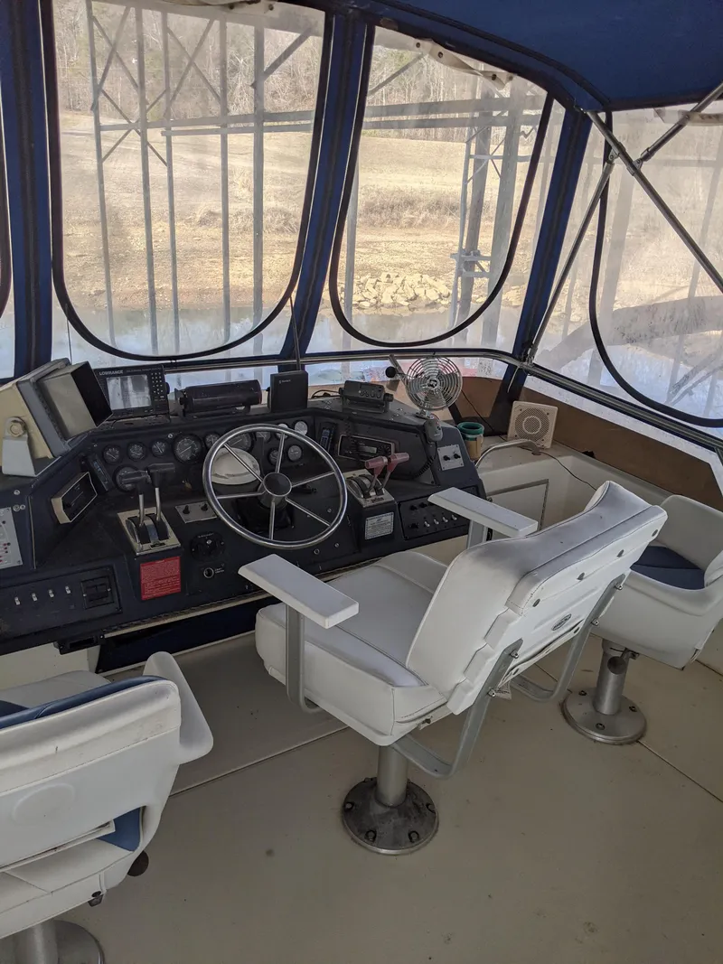 Slide: The Image of 1989 Sea Ray 380 Aft Cabin helm with white captain's chairs and navigation equipment. - 18