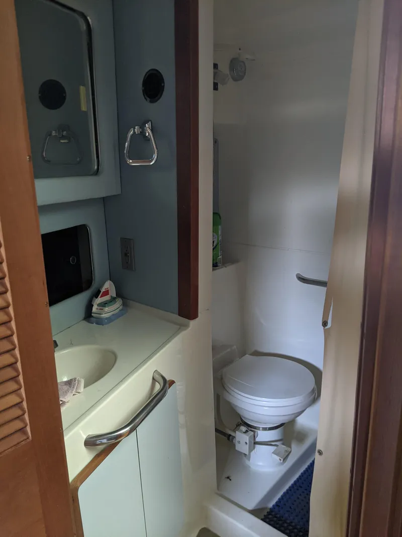 Slide: The Image of 1989 Sea Ray 380 Aft Cabin bathroom with sink, mirror, and toilet. - 24