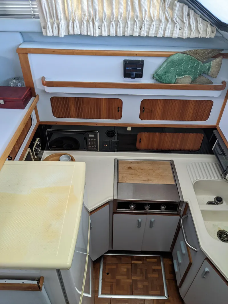 Slide: The Image of 1989 Sea Ray 380 Aft Cabin kitchen with wooden cabinets and appliances. - 30