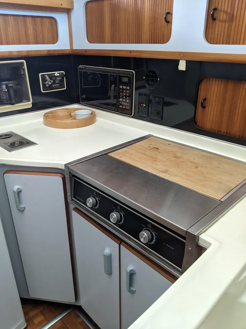 Slide: The Image of 1989 Sea Ray 380 Aft Cabin kitchen with stove, cabinets, and countertop. - 31