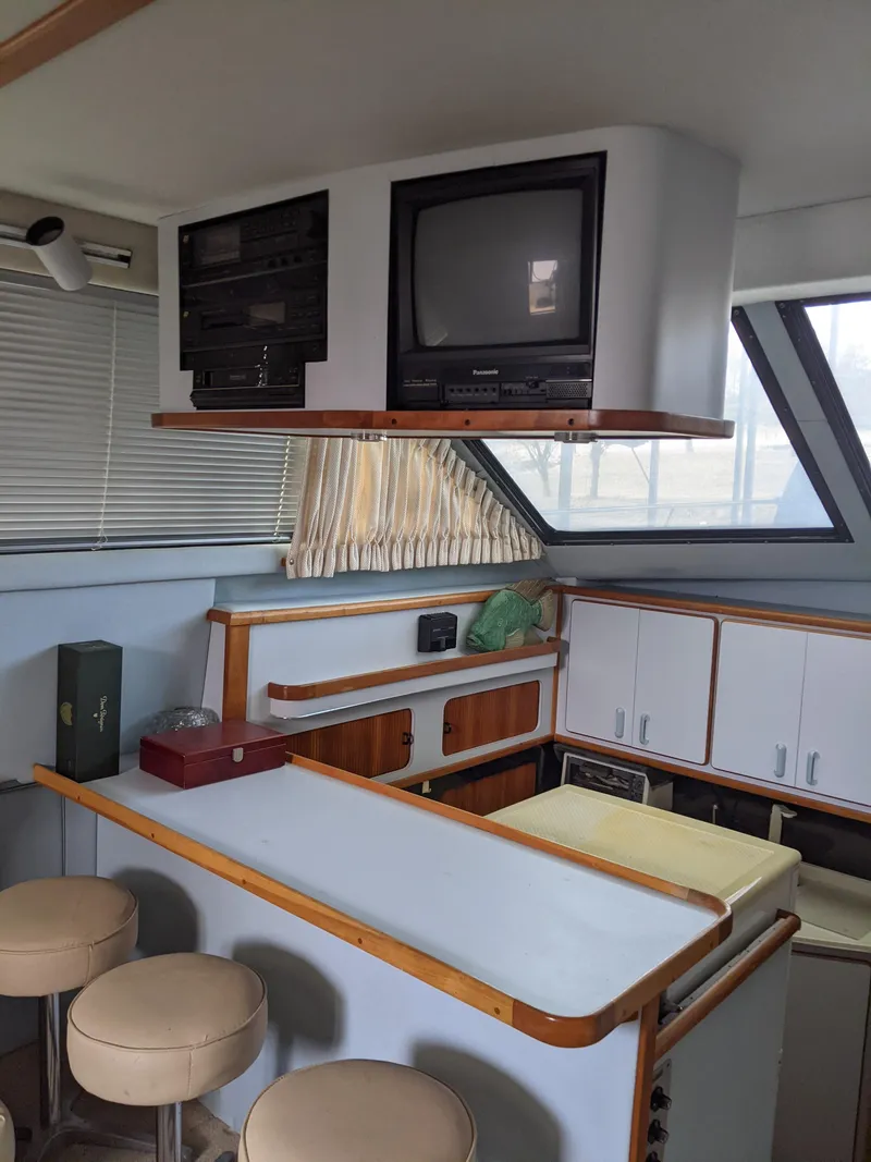 Slide: The Image of Interior of 1989 Sea Ray 380 Aft Cabin with TV and bar stools. - 33