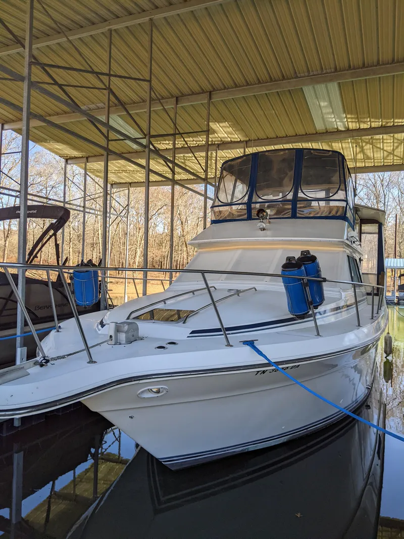 Slide: The Image of 1989 Sea Ray 380 Aft Cabin boat docked under a covered marina. - 48