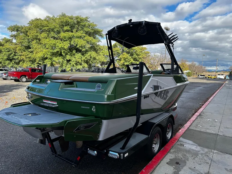 Slide: The Image of 2021 Axis T22 green and white boat on a trailer, parked on a street. - 11