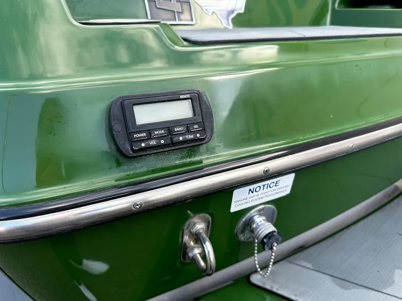 Slide: The Image of 2021 Axis T22 boat with green exterior, digital display, and notice label. - 18