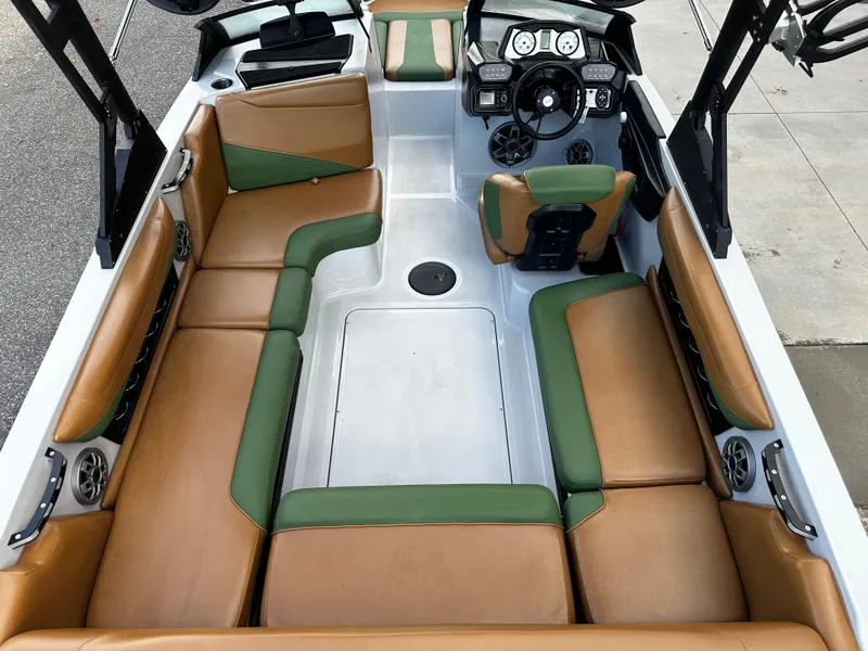 Slide: The Image of 2021 Axis T22 boat interior with tan and green seating, modern dashboard, and spacious layout. - 20